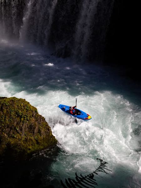 La Française Nouria Newman fait du kayak devant un arc-en-ciel créé par une chute.