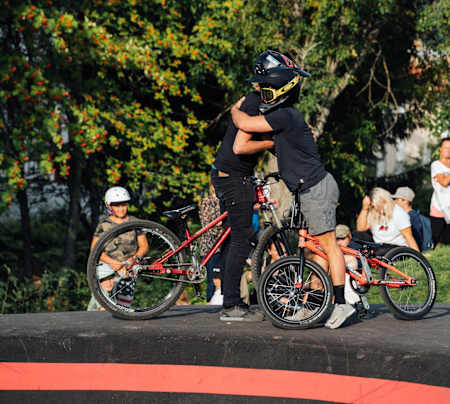 Competitors hug after riding pump track in Sweden.