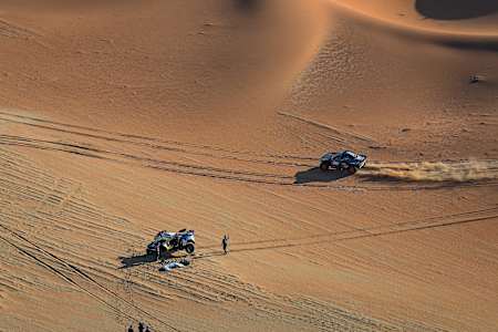 Carlos Sainz pasando al lado del coche de Nasser Al-Attiyah con un problema mecánico en su coche durante la Etapa 6 « 48 Horas Crono » del Dakar 2024