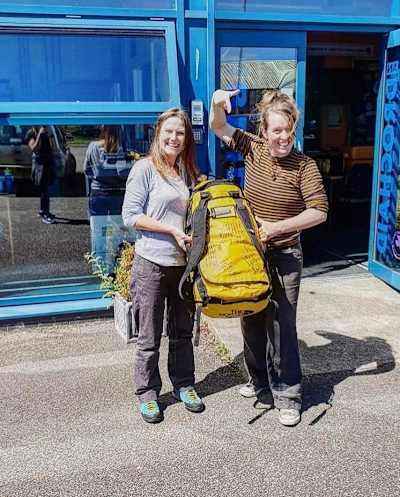 Anna McNuff shows off her backpack with an accommodation host during her Great Britain barefoot ultrarunning attempt in 2019.