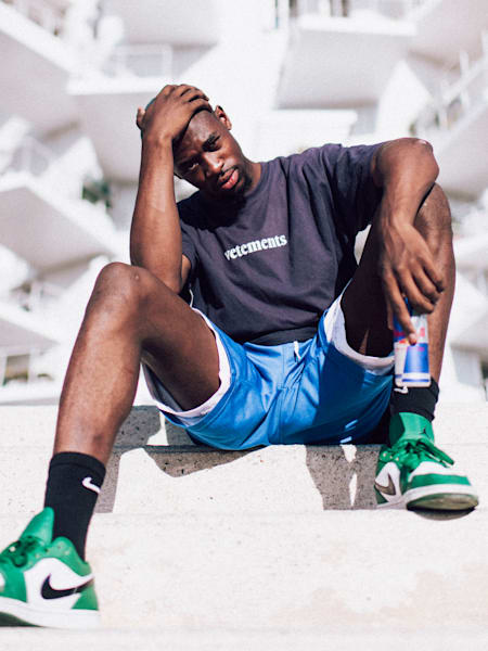 A portrait of Franch dancer Jojo Akamz in front of a white building.