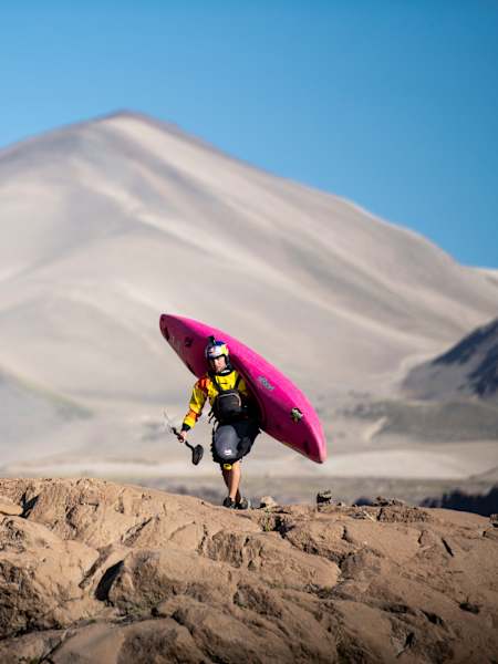Le kayakiste Dane Jackson porte son kayak pendant une expedition de kayak au Chili.
