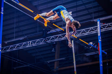 Armand Duplantis réalise un saut à la perche lors d'une compétition.