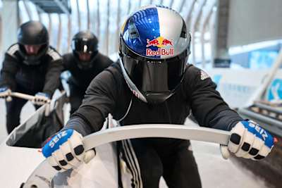 Rostislav Gaitiukevich and his team take off for a push during bobsleigh training.