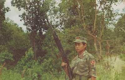 An image of ultrarunner Mira Rai as a 15-year-old in army uniform and carrying a rifle.