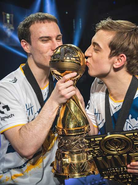 League of Legends players kiss the MSI trophy.