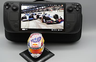 Bild zeigt das Steam Deck OLED mit dem Spiel F1 23 und einem Modell des Helmes von Formel-1-Piloten Max Verstappen