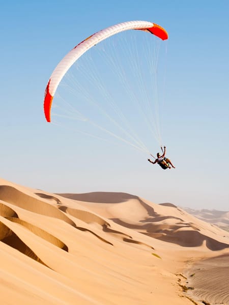 Horacio Llorens en parapente à Sandwich Bay, en Namibie, destination pour un voyage sportif.
