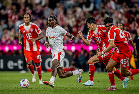 Ezechiel Banzuzi defends the ball against several FC Bayern opponents.