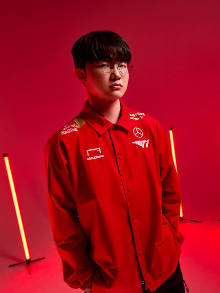 Faker from T1 Esports is captured during a dynamic Red Bull photoshoot in South Korea on 10 July, 2025, set against a bold red backdrop and striking lights.