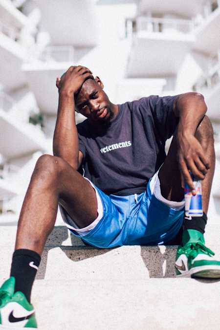 A portrait of Franch dancer Jojo Akamz in front of a white building.