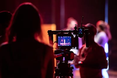 Un cámara graba a unos bailarines durante la producción de un vídeo en un estudio.