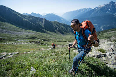 Le parapentiste Aaron Durogati marche sur les sentiers de Cari en Suisse lors du raid Red Bull-Alps.