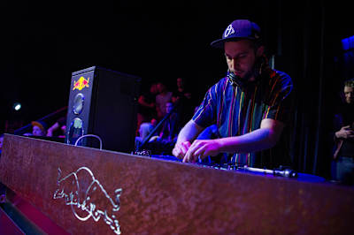 El DJ Fleg detrás de una mesa con el logotipo de Reb Bull.