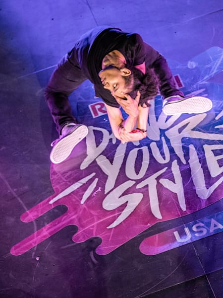 Skitzo is posing on his knees with the back arched and doing a flexible gesture with the hands.