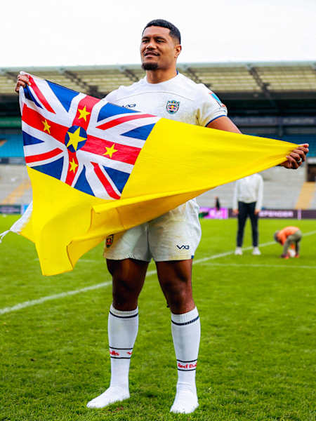 Zuriel Togiatama holding flag of Niue following club debut