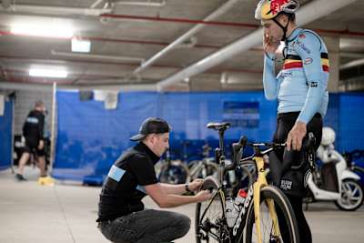Ein Mechaniker wechselt den Reifen am Bike von Wout van Aert.