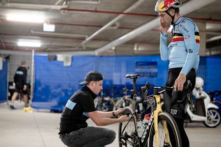 Ein Mechaniker wechselt den Reifen am Bike von Wout van Aert.