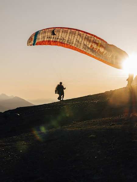 On June 22, 2025, Aaron Durogati takes off from Fuorcla Stragliavita, Switzerland, during the adrenaline-filled adventure of Red Bull X-Alps, soaring into the sunset