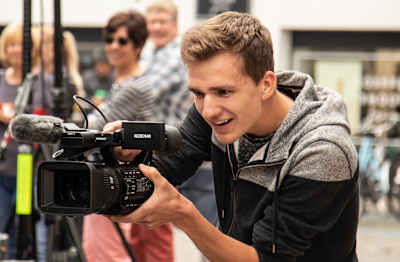 A man films with a video camera.