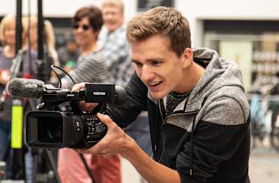 A man films with a video camera.