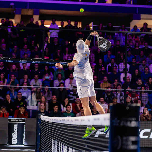 Alejandro Galán takes a mid-air swing to deliver an over-the-net shot during a Premier Padel match