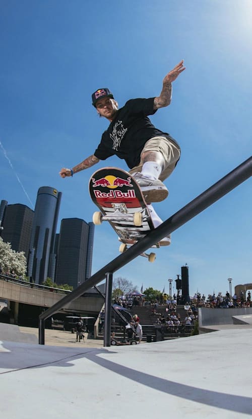 Ryan Sheckler on the rail against a blue sky background with the sun shining