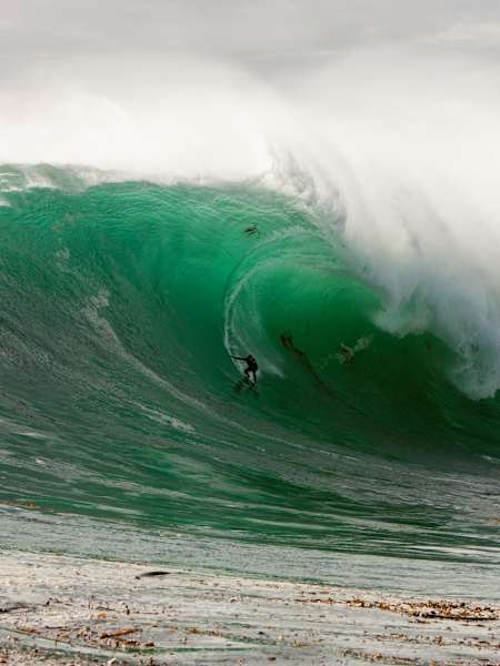 Professional big wave surfer from Brazil, Carlos Burle, rides a huge wave at California's Ghost Tree.