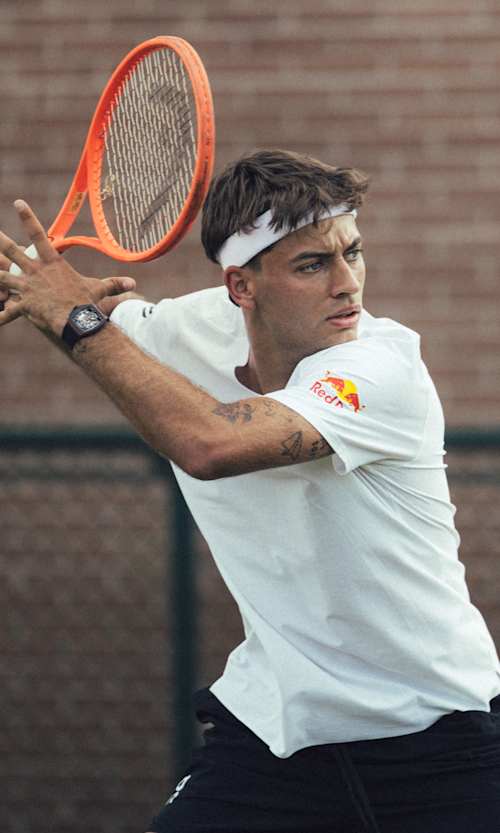 Italian tennis player Flavio Cobolli prepares to strike the ball.