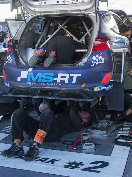 M-Sport mechanics hard at work atop their Ford Fiesta WRC in the service area