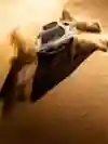 A rally car send sand flying in the dunes during the Dakar Rally.