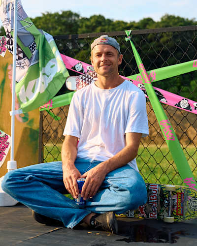Madars Apse sits cross-legged on his skateboard