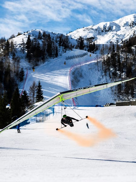 Wolfgang Siess performing a speedrun over a ski slope with his hang glider