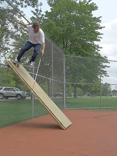 Cane assisted tail drop on a wooden bank