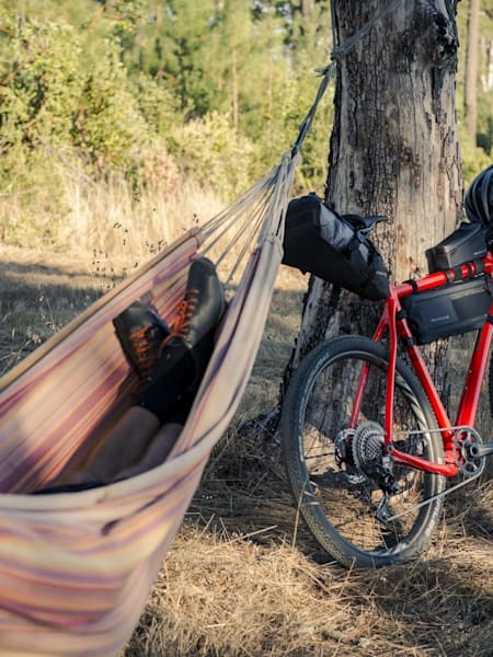 Person in a hammock with bike packed ready for adventure.