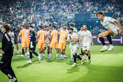 Zwei Teams klatschen kurz vor Anpfiff des Matches ab.