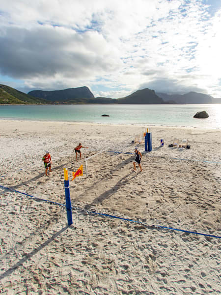 Des joueurs s'affrontent sur une plage lors d'un match de beachvolley.