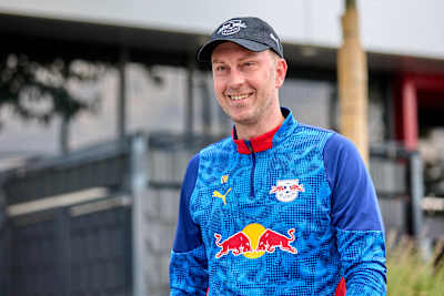Ole Werner grinning while wearing a cap and RB Leipzig kit.