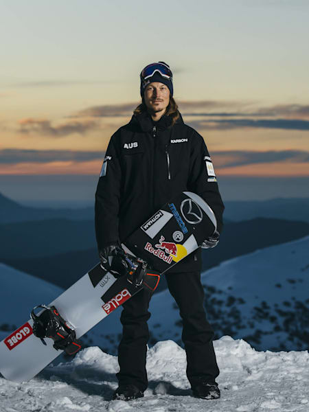 Australian boardercross champion, Alex Chumpy Pullin poses on top of a mountain