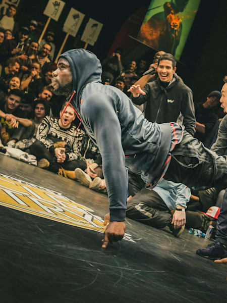 Junior se sujeta con los dedos mientras sus compañeros lo animan.