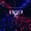 Spectators fill the venue with energy at Red Bull Batalla 2025 in Buenos Aires, Argentina, on July 26, 2025, as competitors face off on stage under vibrant red and blue lights