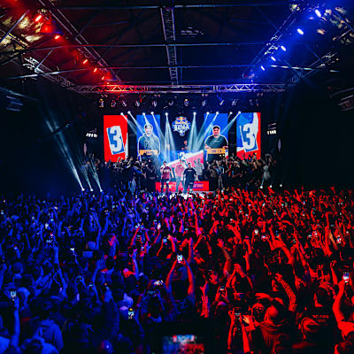 Spectators fill the venue with energy at Red Bull Batalla 2025 in Buenos Aires, Argentina, on July 26, 2025, as competitors face off on stage under vibrant red and blue lights