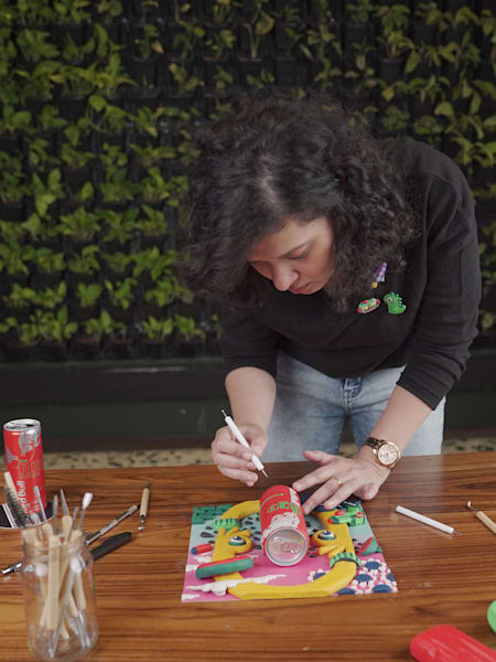Rutuja Mali works on her clay illustration art celebrating the Red Bull Red Edition