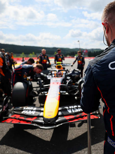 Yuki Tsunoda dans sa RB21, entouré par l'équipe Red Bull Racing sur la grille de départ du Grand Prix de Belgique de Formule 1 2025 sur le circuit de Spa-Francorchamps.