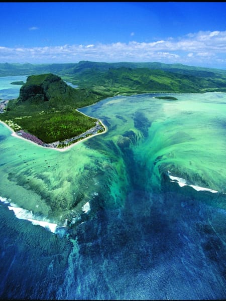 Sand flows out of a lagoon into an ocean