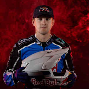 Speedway rider Wiktor Przyjemski holds his Red Bull helmet in a racing suit during a portrait shoot in Toruń, Poland in April 2026