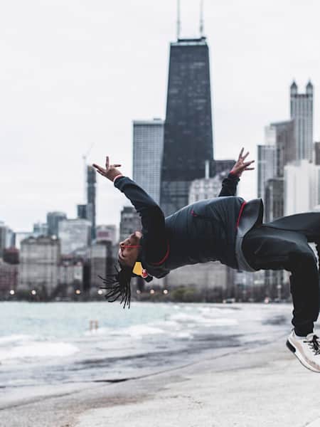 Neguin jumping backwards with the Chicago skyline in the background.