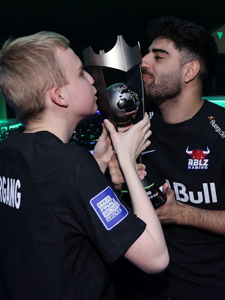 Anders Vejrgang et Umut Gültekin embrassent le trophée après leur triomphe à la Coupe du Monde FIFAe 2023.