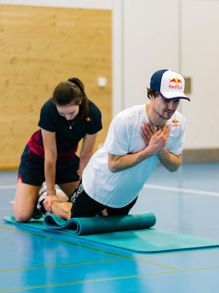 Mathilde Gremaud drückt die Füsse von Fabian Bösch Richtung Boden und bildet so das Gegengewicht für die Nordic Hamstrings