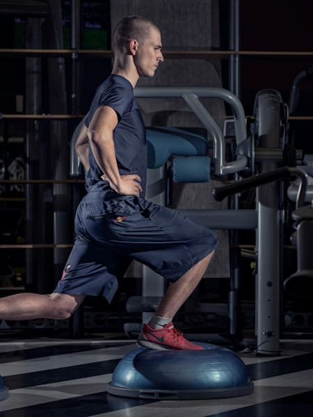 Karel Hanika robi wykroki na piłkach, ćwicząc równowagę